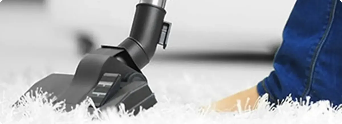 Close-up of a professional vacuuming a white carpet in Thornton.